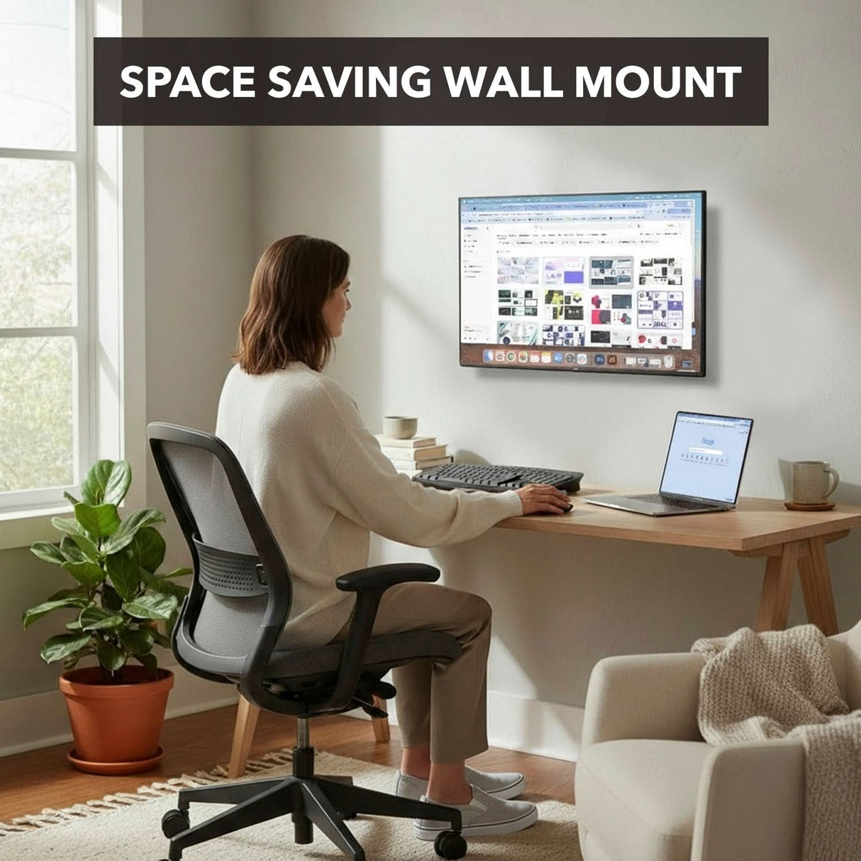 A woman works at a wood desk with a Mount-It! Tilting TV Wall Mount holding her desktop computer, a laptop beside her. The minimal workspace includes a chair and potted plant. Text reads: Space Saving Wall Mount.