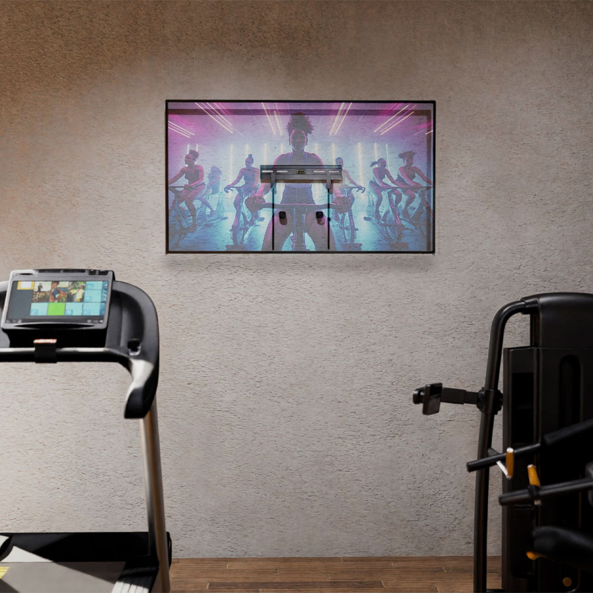 No Stud TV Wall Mount for TVs 23" - 65" installed on a textured wall in a home gym setting, holding a flat screen TV streaming a fitness class, showcasing its low-profile design, clean mounting without visible studs or damage, and suitability for spaces like bedrooms, apartments, or offices where easy, damage-free installation is key.