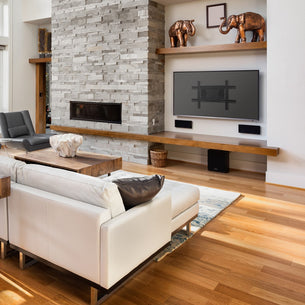 Modern living room with white sofa, stone fireplace, and a wall mounted TV. Modern living room with white sofa, stone fireplace, and a wall mounted TV.