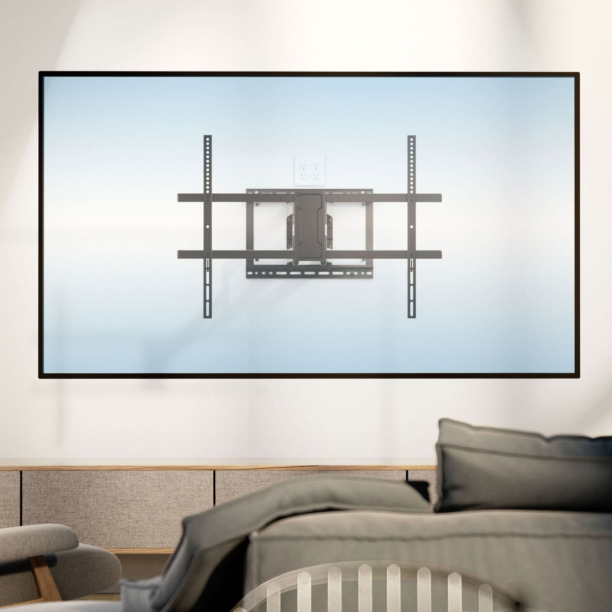 The Mount-It! Full Motion TV Wall Mount with Extra Long Extension is installed on a light blue wall in a modern living room. It features swivel and tilt adjustments, an overhead electrical outlet, and a couch for comfortable viewing.