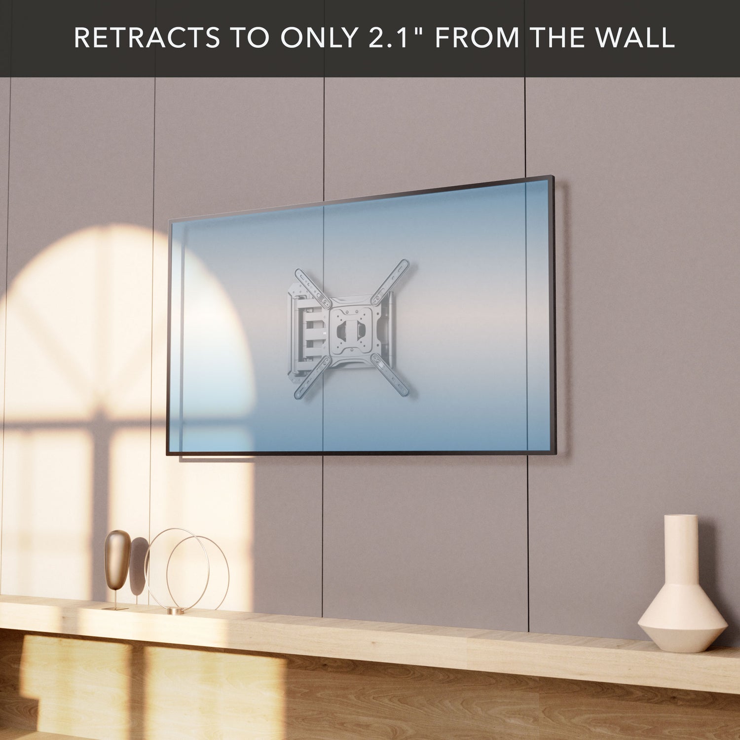 Full Motion TV Wall Mount with Extra Long Extension for 23 to 65 inch TVs shown retracted to 2.1 inches from the wall, mounted on a neutral gray panel above a wooden shelf with decorative items, demonstrating sleek low-profile design and secure steel construction for space-saving setup.