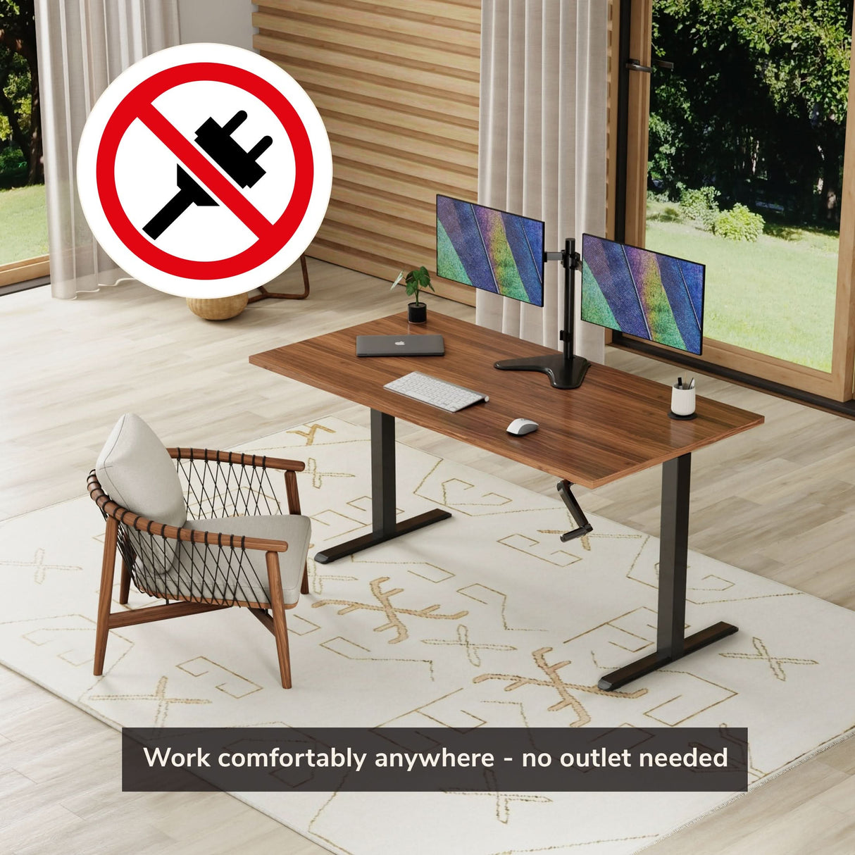 A modern home office features the Mount-It! Standing Desk Frame with Hand Crank, two monitors, a chair, and a large window. A "no outlet" symbol and text read: "Work comfortably anywhere – no outlet needed.