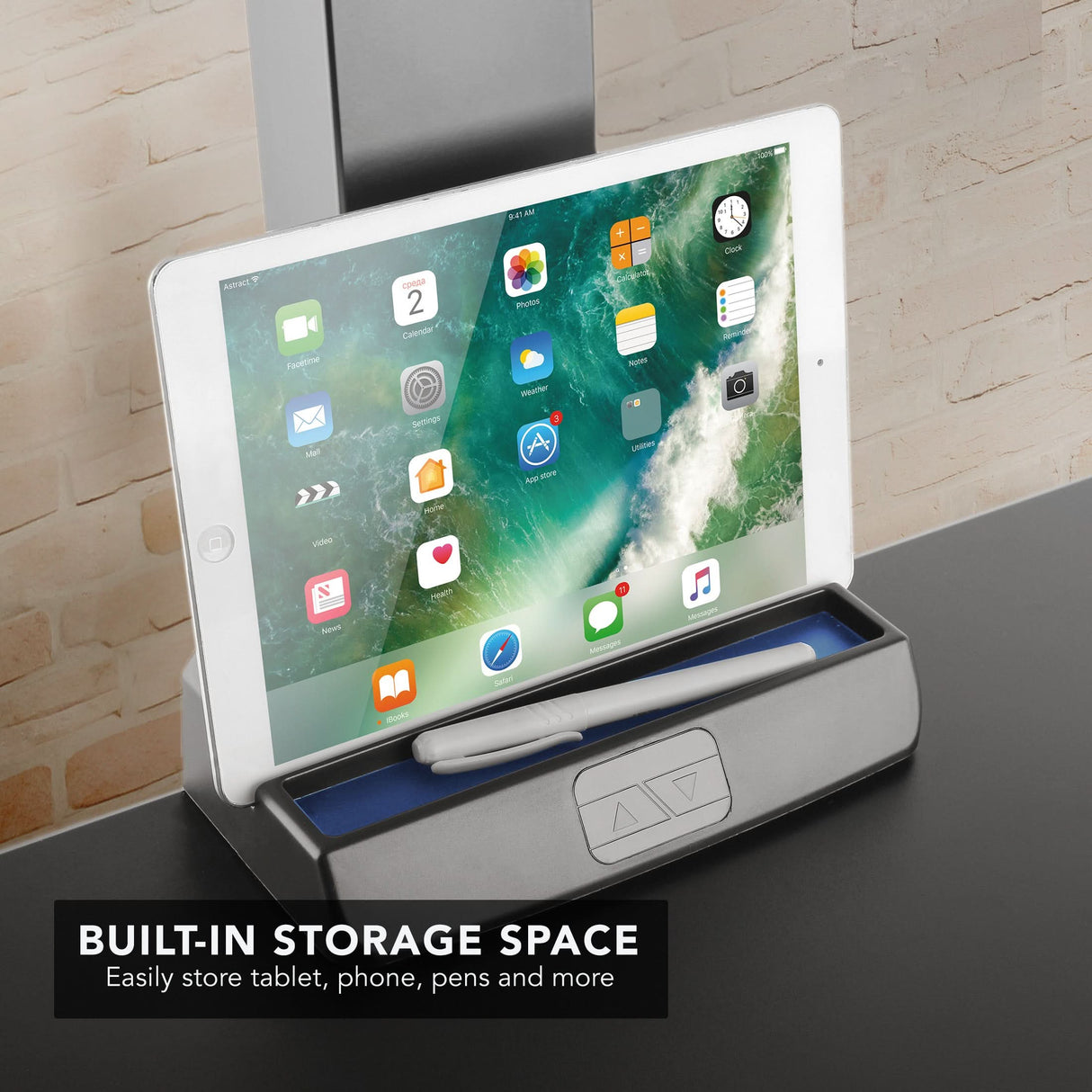 Electric standing desk converter holding a white tablet in the built in storage space