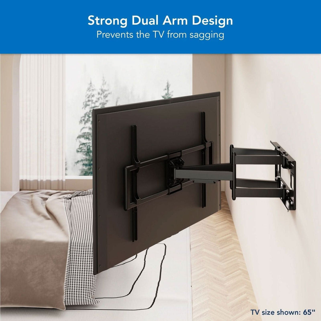 A 65-inch TV is mounted above a bed with the Mount-It! Heavy Duty Full Motion TV Wall Mount, which extends from the wall for stability. Snowy scenery can be seen through the window.