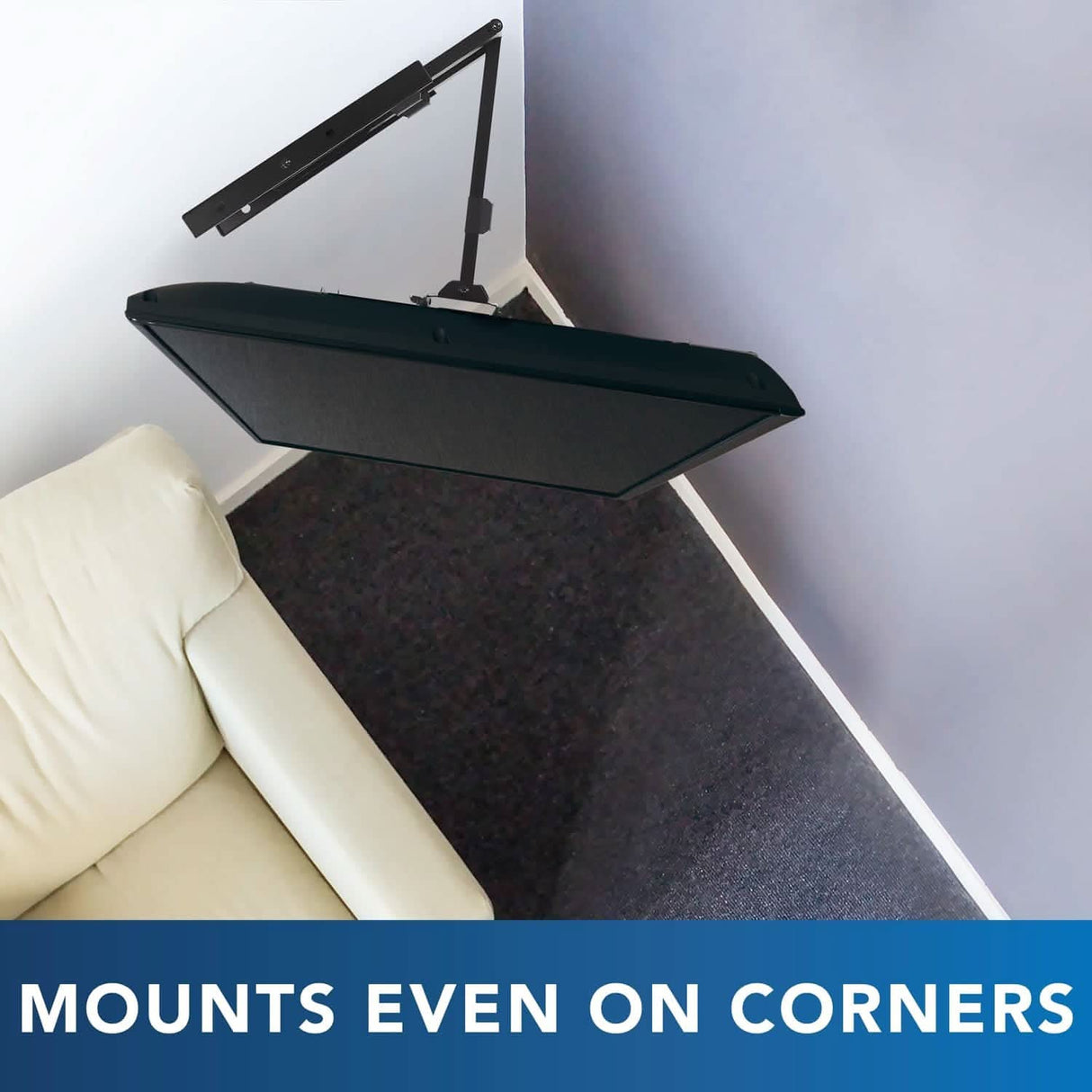 A beige couch sits below a flat-screen TV installed on the Mount-It! Full Motion TV Wall Mount with Extra Long Extension, positioned in the corner, with the text "MOUNTS EVEN ON CORNERS" at the bottom.