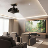 A modern home theater room with gray recliners and a vivid jungle scene on a large screen, featuring the Mount-It! Heavy-Duty Universal Projector Ceiling Mount and soft ambient lighting for an immersive experience.