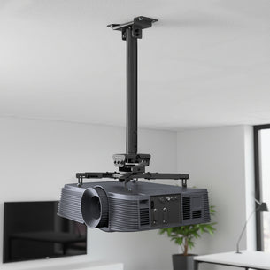 The Mount-It! Heavy-Duty Universal Ceiling Projector is mounted on an adjustable bracket in a modern, bright room with white walls and a TV in the background.
