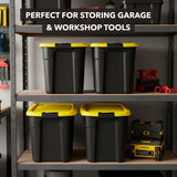 Four Mount-It! Heavy-Duty Storage Bins with Lids in black and yellow are stacked on garage shelves among tools and equipment. Text overlay: “Perfect for storing garage & workshop tools.”.