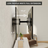Side view of a heavy duty full motion TV wall mount with extension installed on a wall, showing the TV positioned 3.7 inches from the wall when retracted and extended out to 19.6 inches, demonstrating its low profile and full extension capability in a modern living room setting.