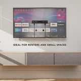 No Stud TV Wall Mount for TVs 23" - 65" installed on a clean wall above a modern floating cabinet in a minimalist room, demonstrating a low-profile, flexible, damage-free mounting solution ideal for renters and small spaces, supporting a large flat-screen TV with streaming apps visible on the screen, emphasizing simplicity and strength without drilling or stud access.