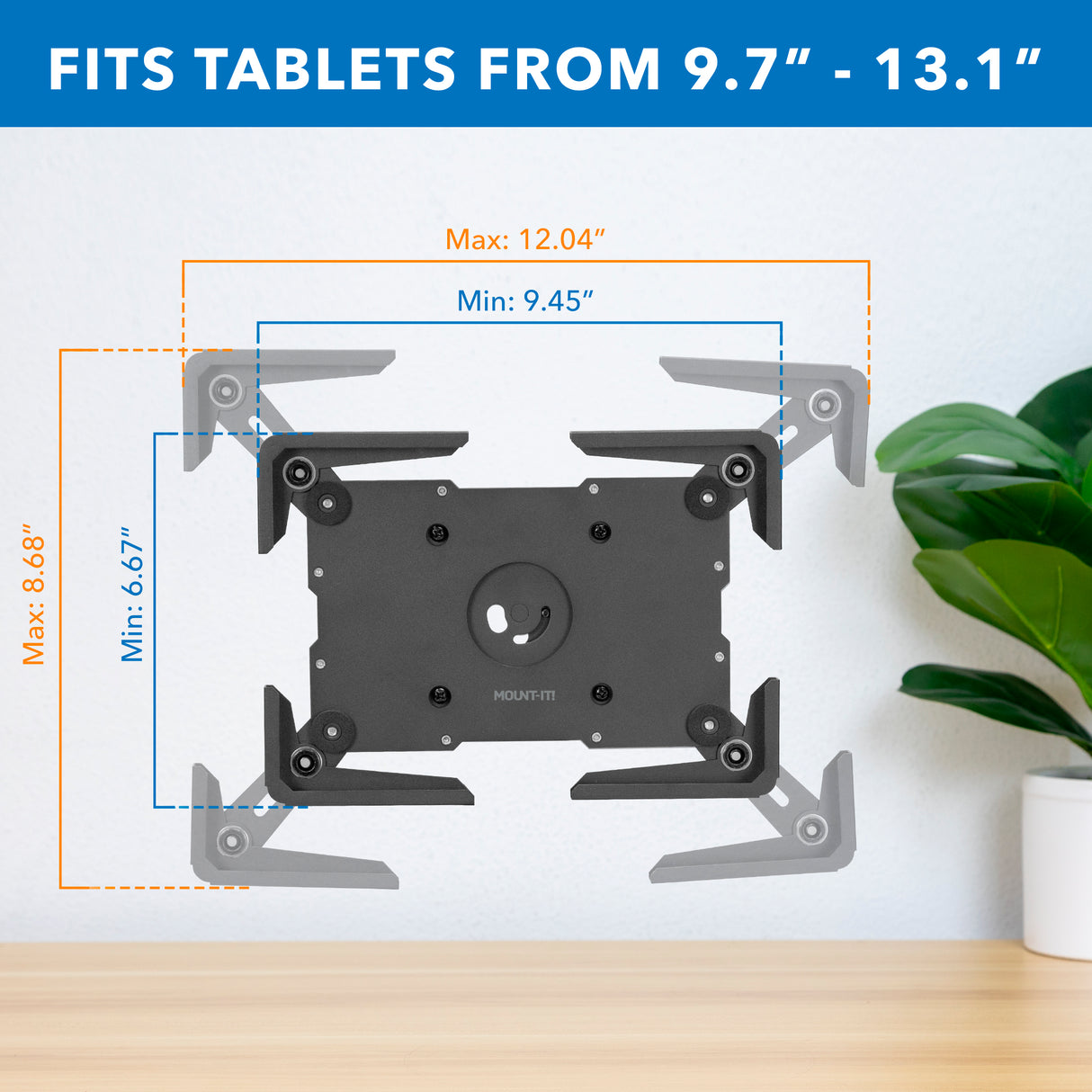 The Mount-It! Universal Tablet Wall Mount has adjustable arms to fit devices from 9.7–13.1", securely enclosing tablets with widths from 9.45–12.04" and heights from 6.67–8.88". A plant is positioned to the right of the mount.