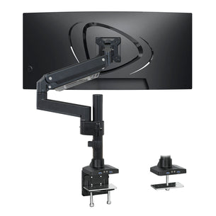 The Mount-It! Heavy Duty Monitor Desk Mount w/ USB & Multimedia Ports in black is attached to a widescreen monitor, featuring adjustable joints, a clamp, and a grommet base for versatile desk installation options.