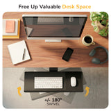 Top-down view: tidy desk with monitor, notebook, phone, cup, plant & headphones. Below: Mount-It! Standing Keyboard and Mouse Platform With Ergonomic Wrist Rest Pad swivels 180° for more desk space. Text: “Free Up Valuable Desk Space. +/- 180° Swivel.”.