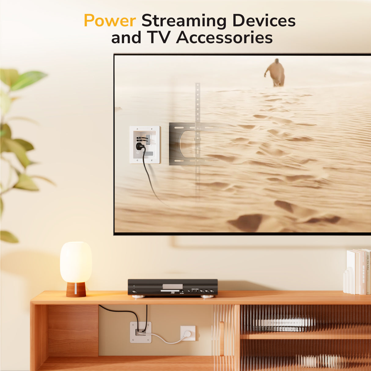 A TV mounted on the wall shows a desert scene. Below, a shelf holds a lamp and device powered by the Mount-It! In-Wall Cable Management Kit with USB, keeping cables organized. Text above says, “Power Streaming Devices and TV Accessories.”.