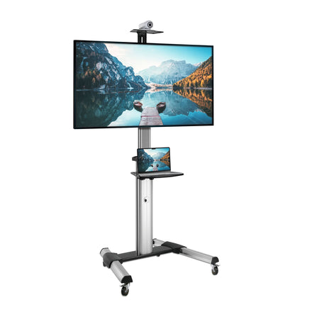 The Mount-It! Heavy Duty Mobile TV Cart with locking casters holds a large flat-screen monitor showing a scenic lake and mountains, features a smaller device on its lower shelf, and has a camera mounted above the screen.